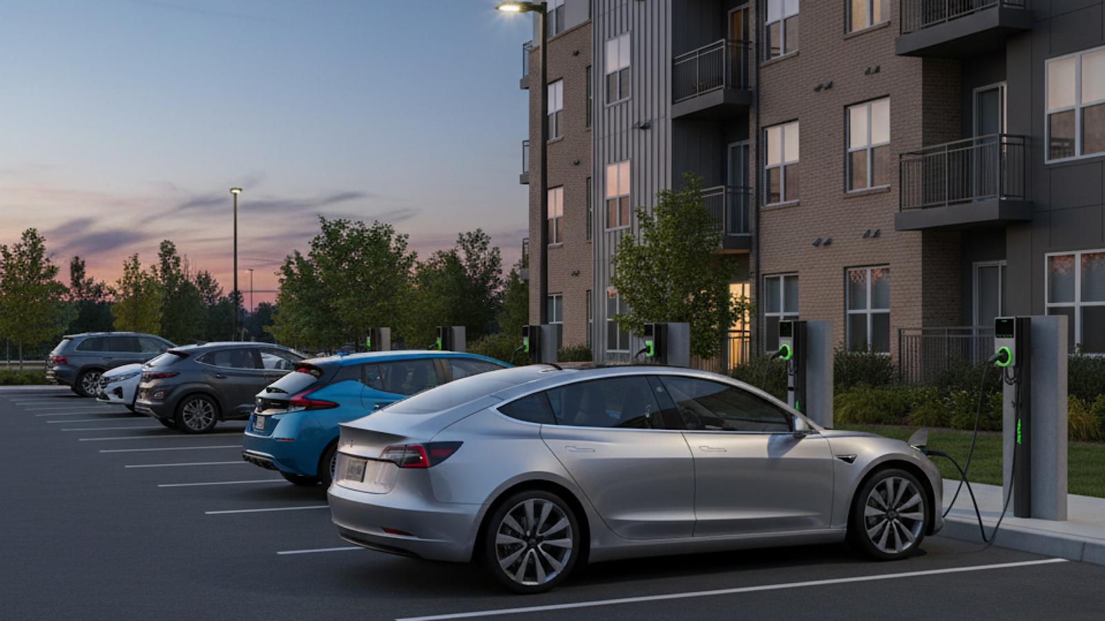 EV charging in front of a glass building at sunset